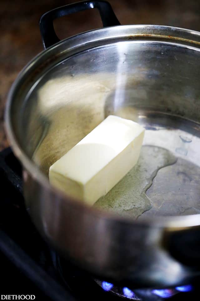 A stick of butter melting in a saucepan.