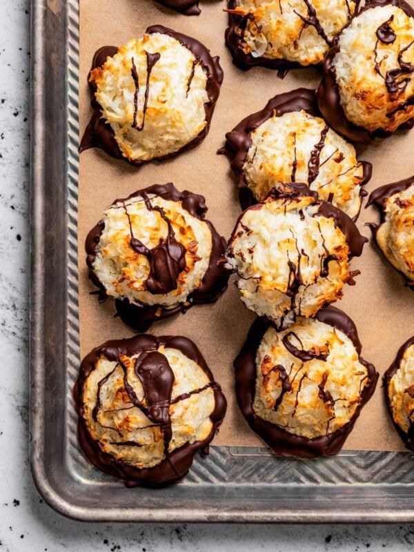 Macaroons arranged on a parchment paper lined baking sheet.
