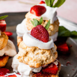 Strawberry shortcake served on a dark platter.