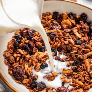 Pouring milk into a bowl of granola.