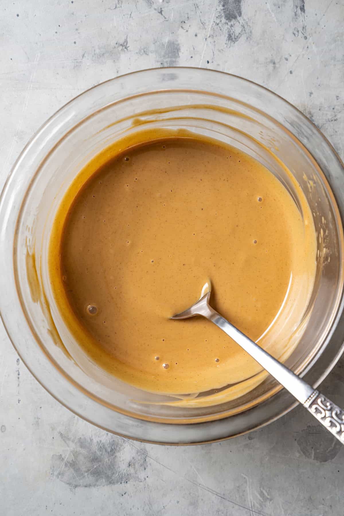 Melted white chocolate and peanut butter in a glass bowl.