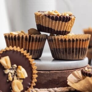 Side view of three peanut butter cups stacked, with a fourth on its side in the foreground.