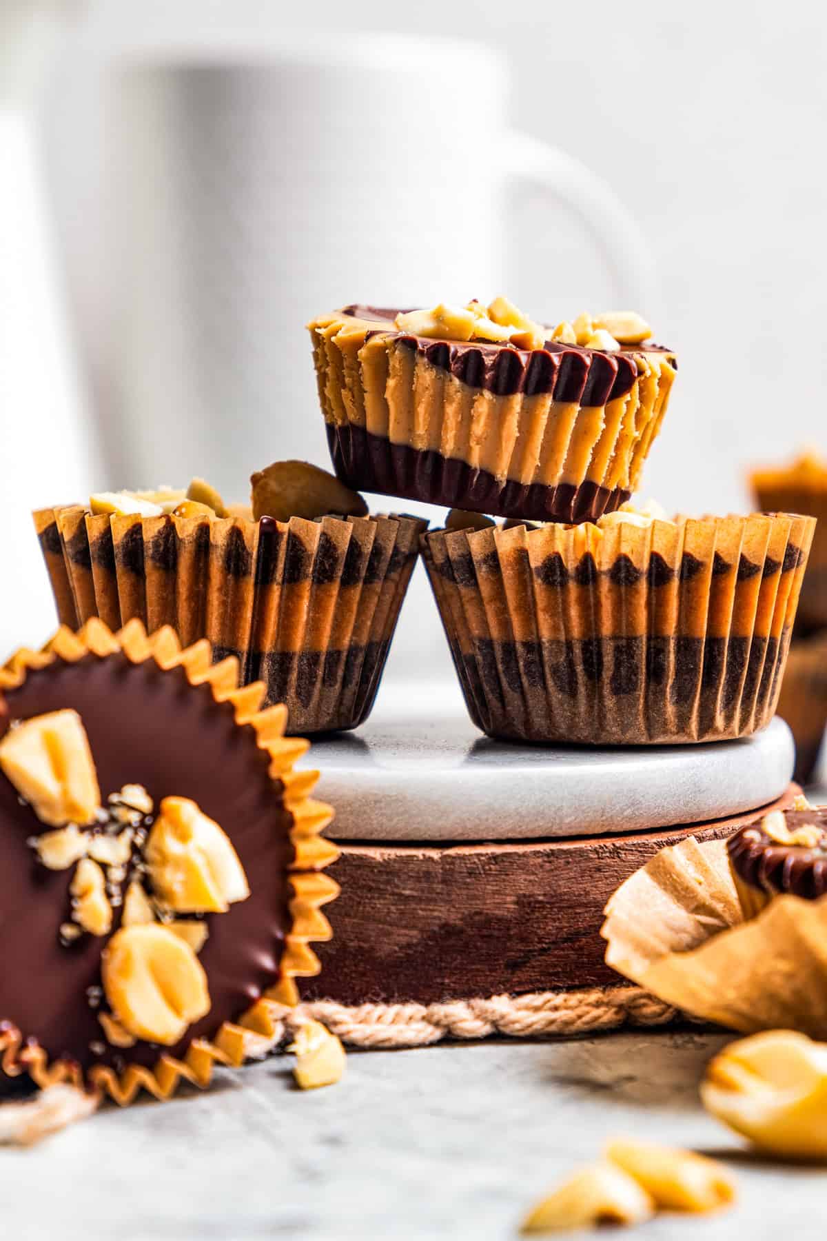 Side view of three peanut butter cups stacked, with a fourth on its side in the foreground.