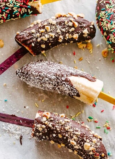 Chocolate dipped bananas topped with sprinkles, nuts, and coconut.