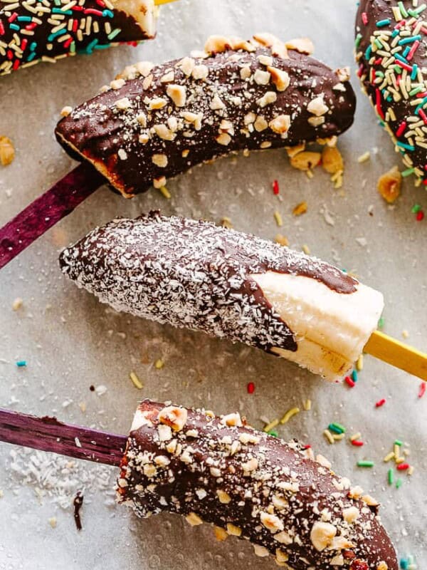 Chocolate dipped bananas topped with sprinkles, nuts, and coconut.