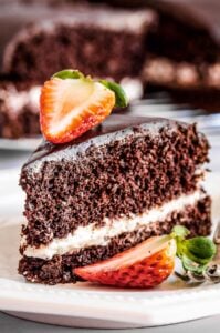 A slice of chocolate olive oil cake topped with strawberries.