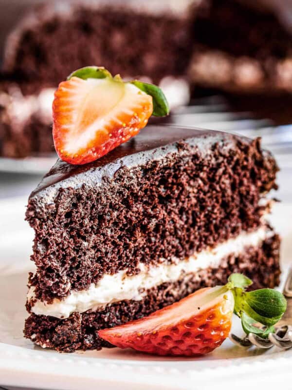 A slice of chocolate olive oil cake topped with strawberries.