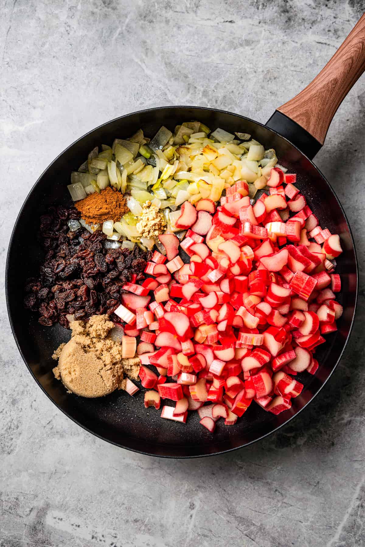 This easy rhubarb chutney is the best way to use fresh rhubarb! It’s sweet and tangy with warm spice, and delicious with just about anything! Chopped rhubarb, onions, brown sugar, raisins, and seasonings in a skillet.