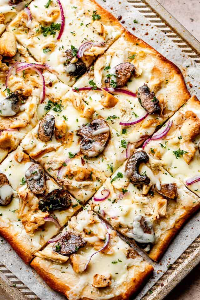 grilled pizza with toppings set on top of a baking sheet