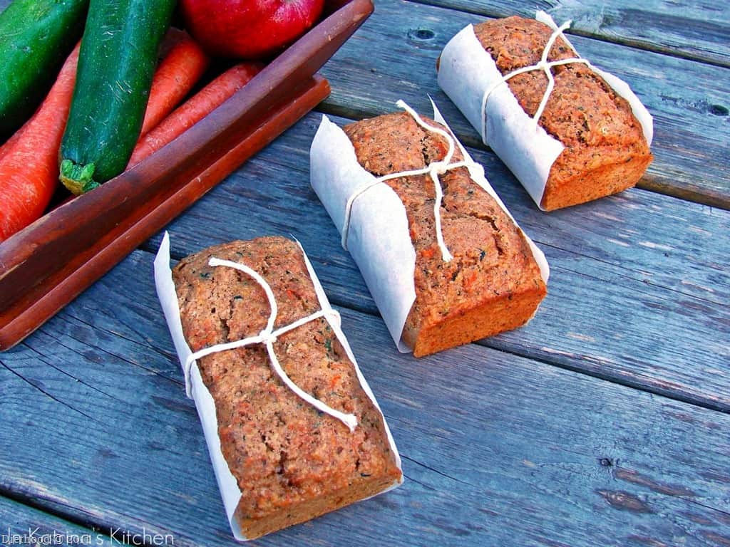 Loaves of fruit and veggie bread tied in parchment paper.