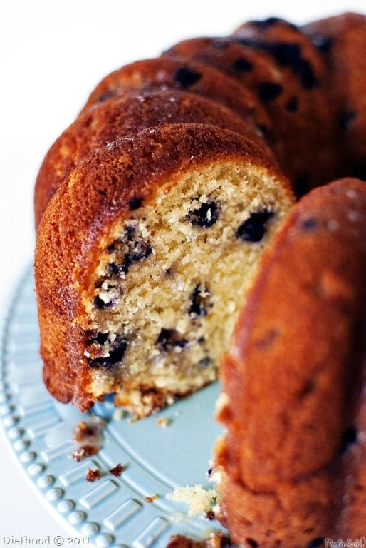 Lemon blueberry pound cake with a slice taken out of it. 