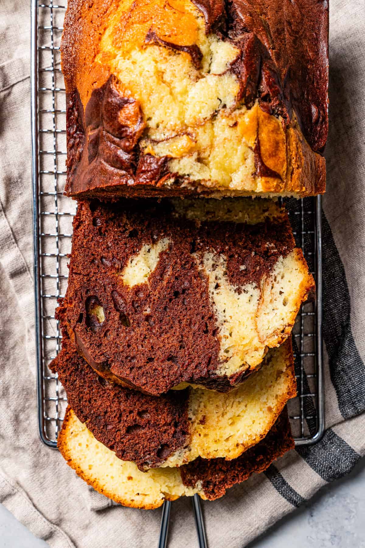 German marble cake resting on a wire rack.