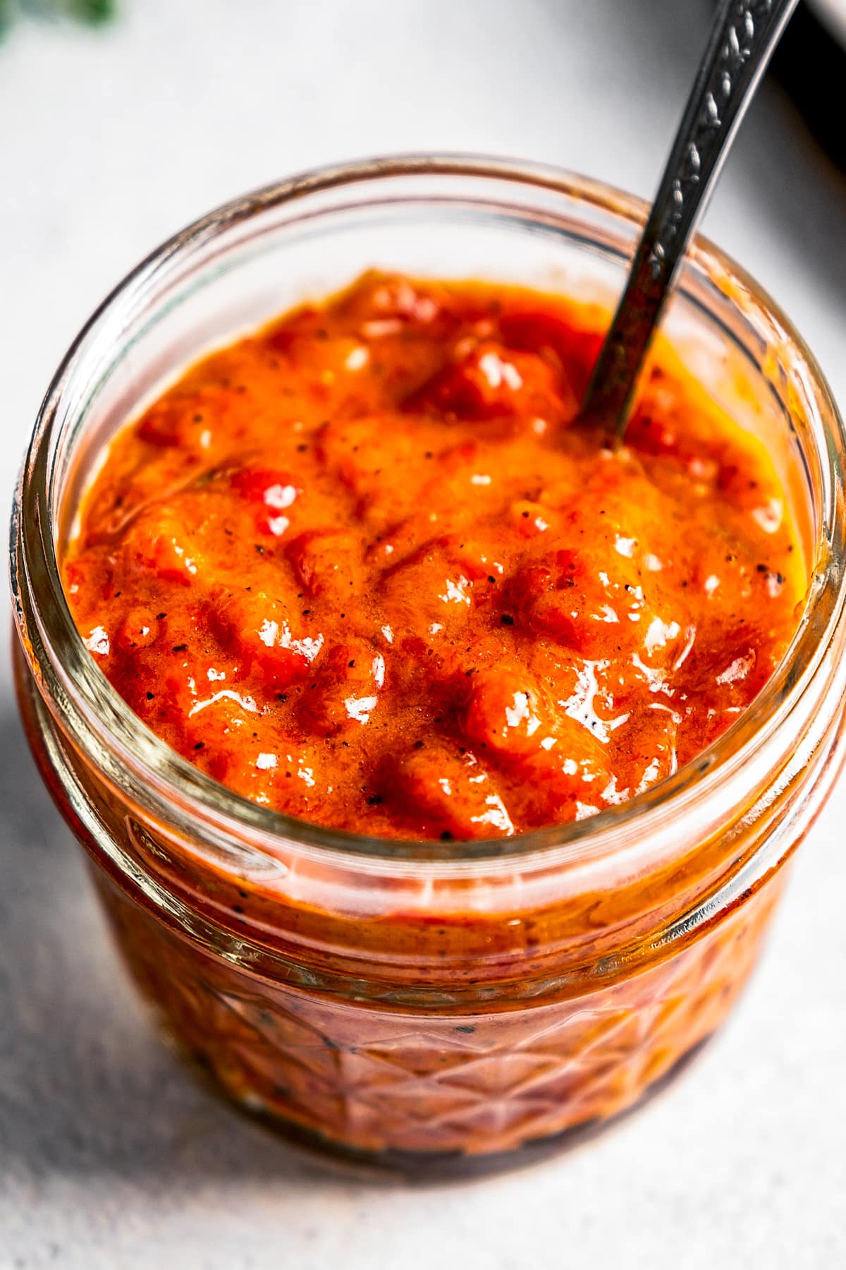 A jar of Ajvar with a spoon.