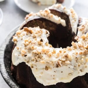 Banana zucchini Bundt cake topped with maple cream cheese frosting and chopped walnuts.