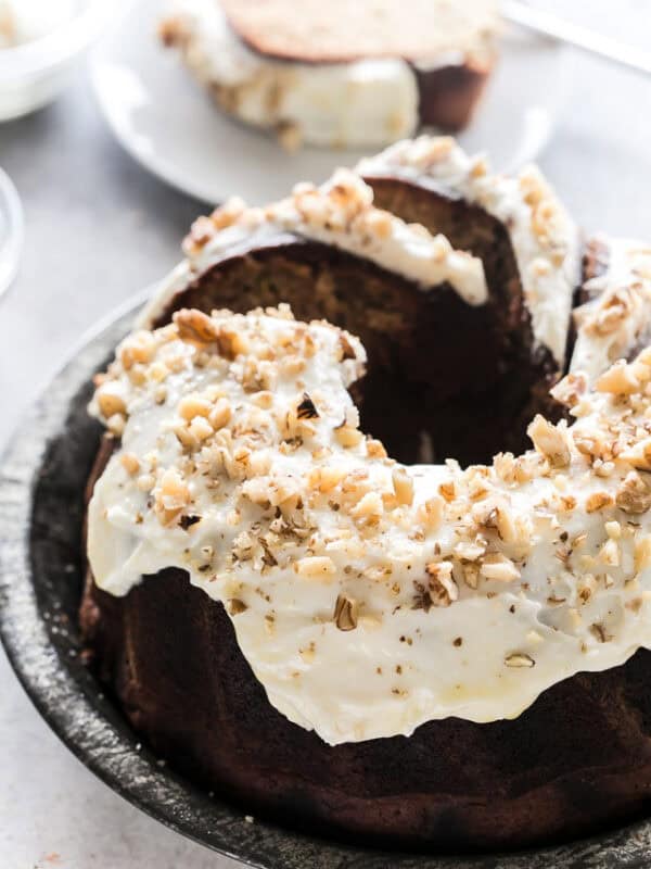Banana zucchini Bundt cake topped with maple cream cheese frosting and chopped walnuts.