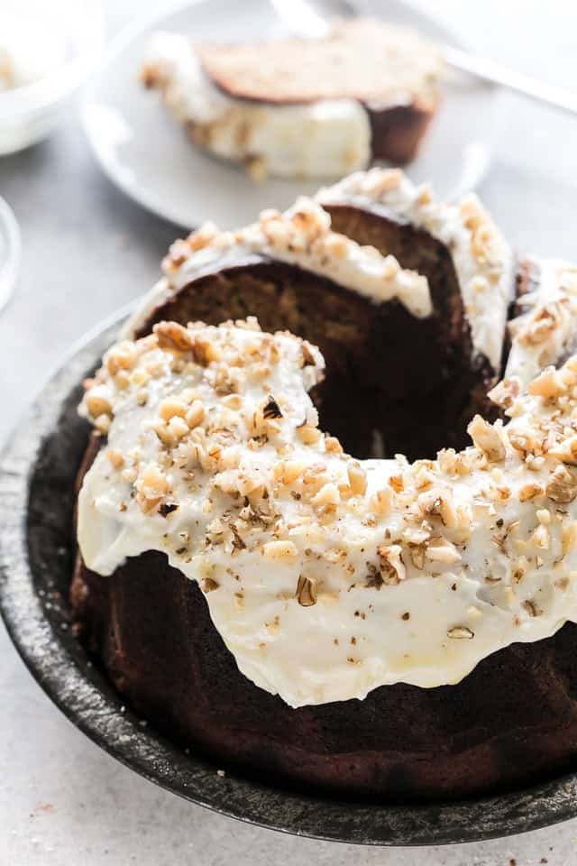 This moist banana zucchini cake is made with ripe bananas, fresh zucchini, and warm spices, then topped with maple cream cheese frosting and walnuts. Banana zucchini Bundt cake topped with maple cream cheese frosting and chopped walnuts.