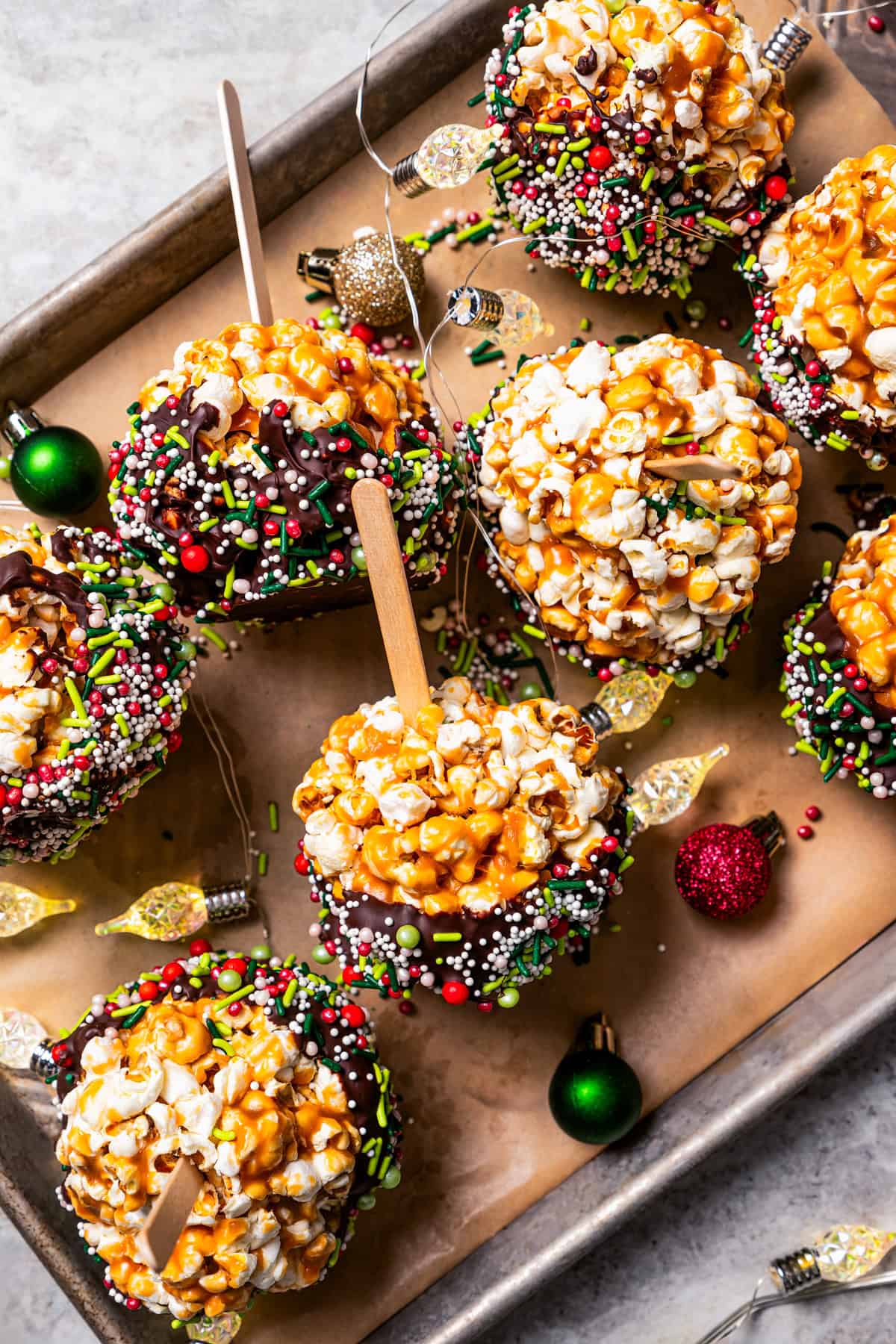 Homemade caramel popcorn balls arranged on a baking sheet.