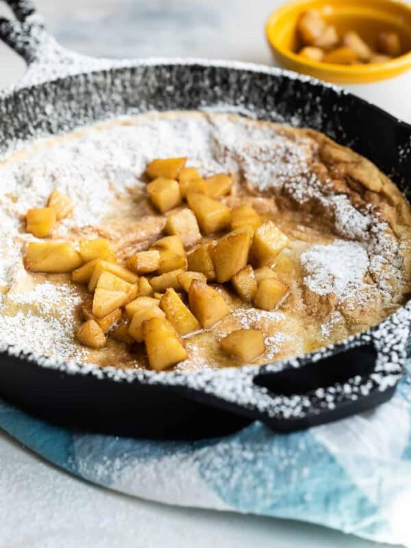 Fried apples on top of a Dutch baby pancake.