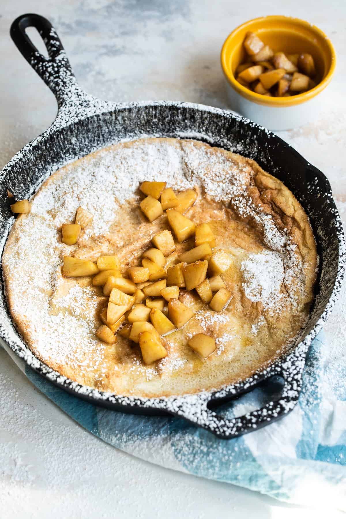 Puffed up Dutch baby pancake with fried apples.