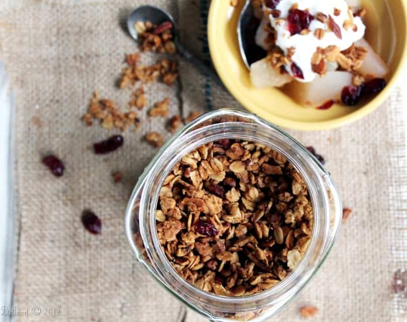 Jar of granola made with nuts, dried fruit, and maple syrup.