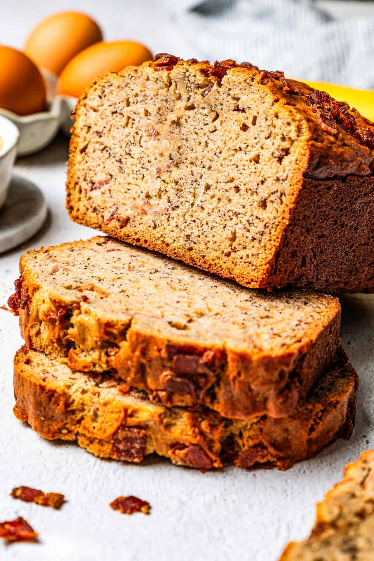 Loaf of peanut butter banana bread propped up on top of two thick slices.