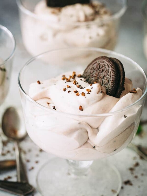 Cheesecake mousse served in a glass dessert bowl, and garnished with an Oreo cookie.