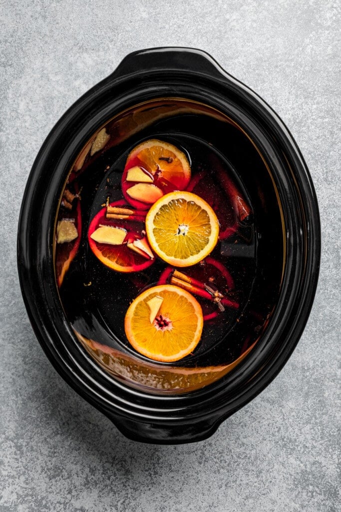 Mulled wine ingredients combined inside the slow cooker.