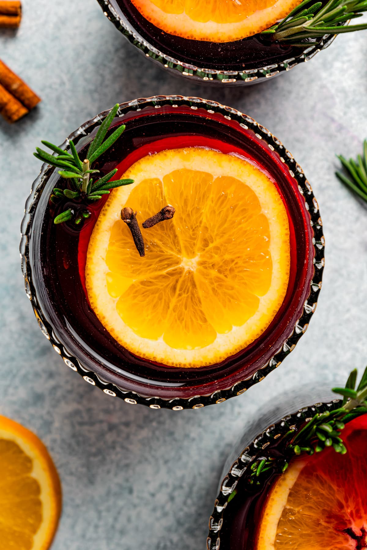 Overhead view of mulled wine served in glasses garnished with orange slices.