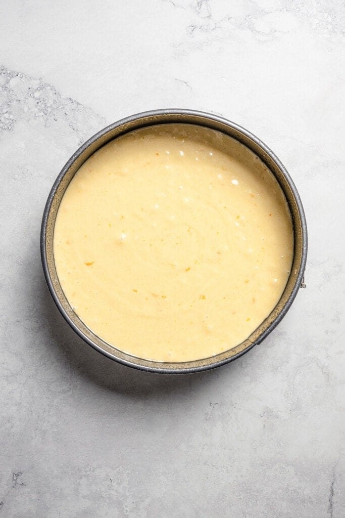 Olive oil cake batter in a round cake pan.