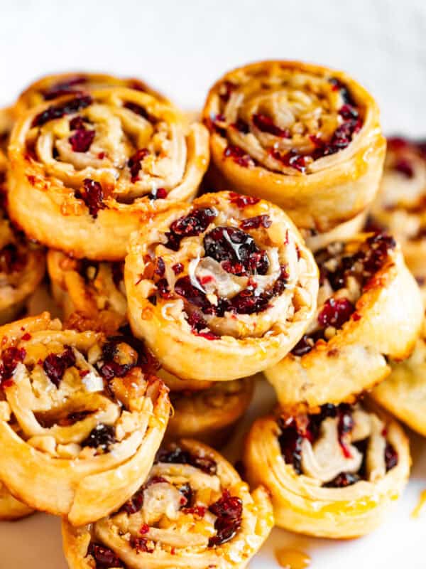 Cranberry walnut pie crust cookies stacked up on a plate.