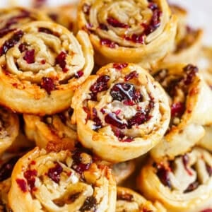 Cranberry walnut pie crust cookies stacked up on a plate.