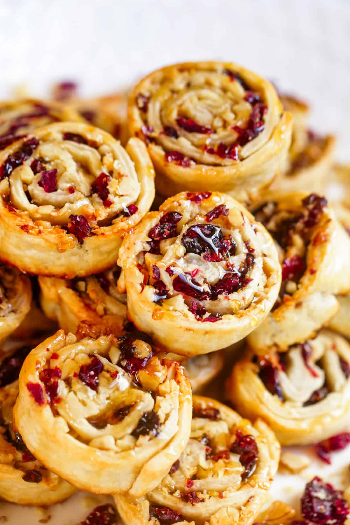 Cranberry walnut pie crust cookies stacked up on a plate.