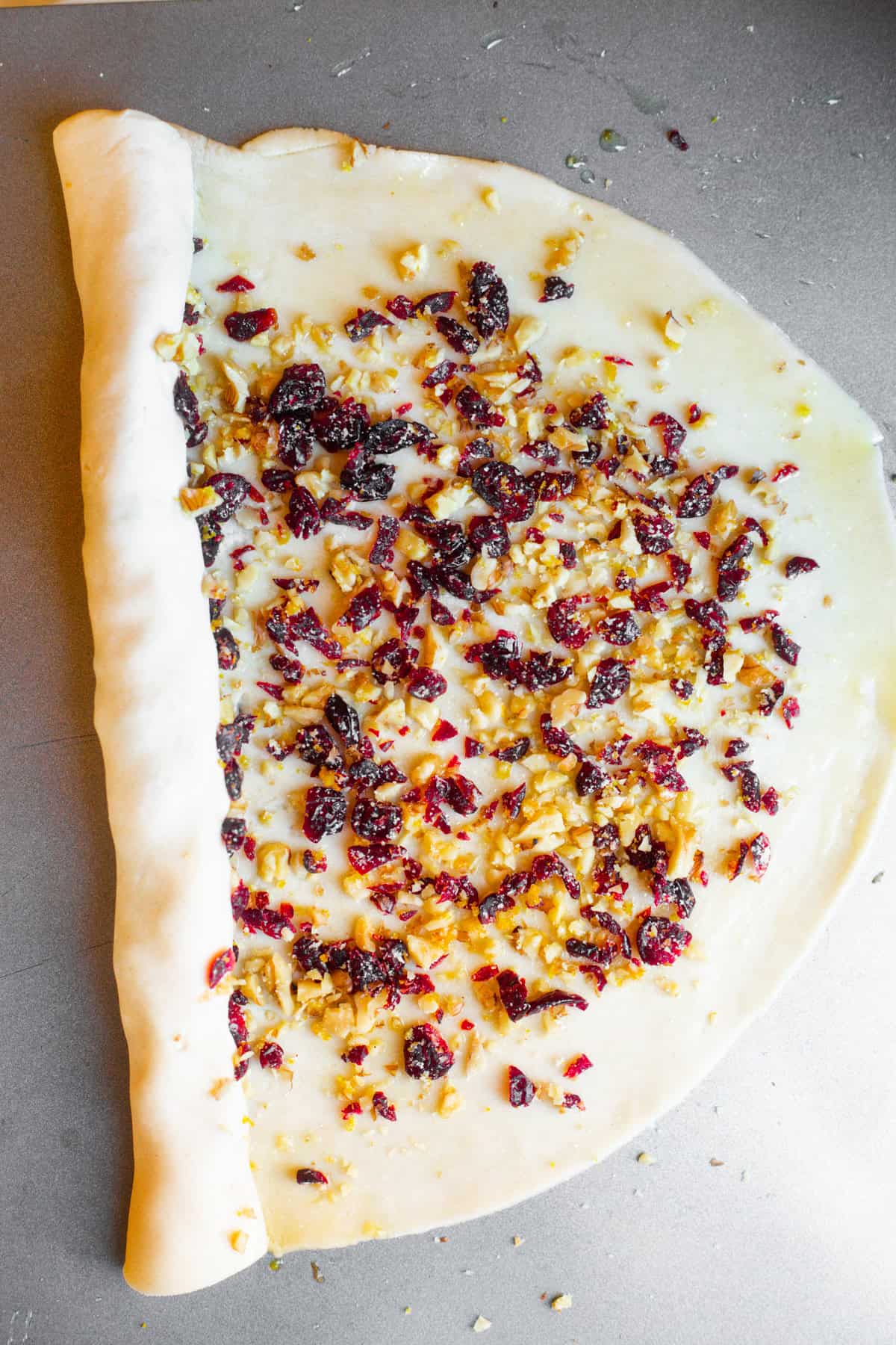 Half-way rolled up pie dough over diced cranberries and nuts.