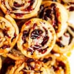 A bunch of stacked up cranberry walnut pie crust cookies.