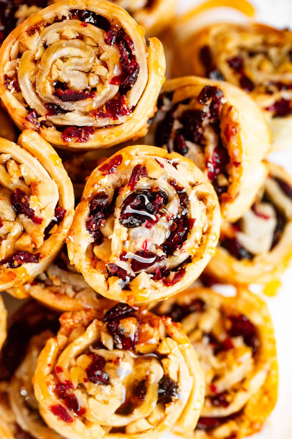 A bunch of stacked up cranberry walnut pinwheel cookies.