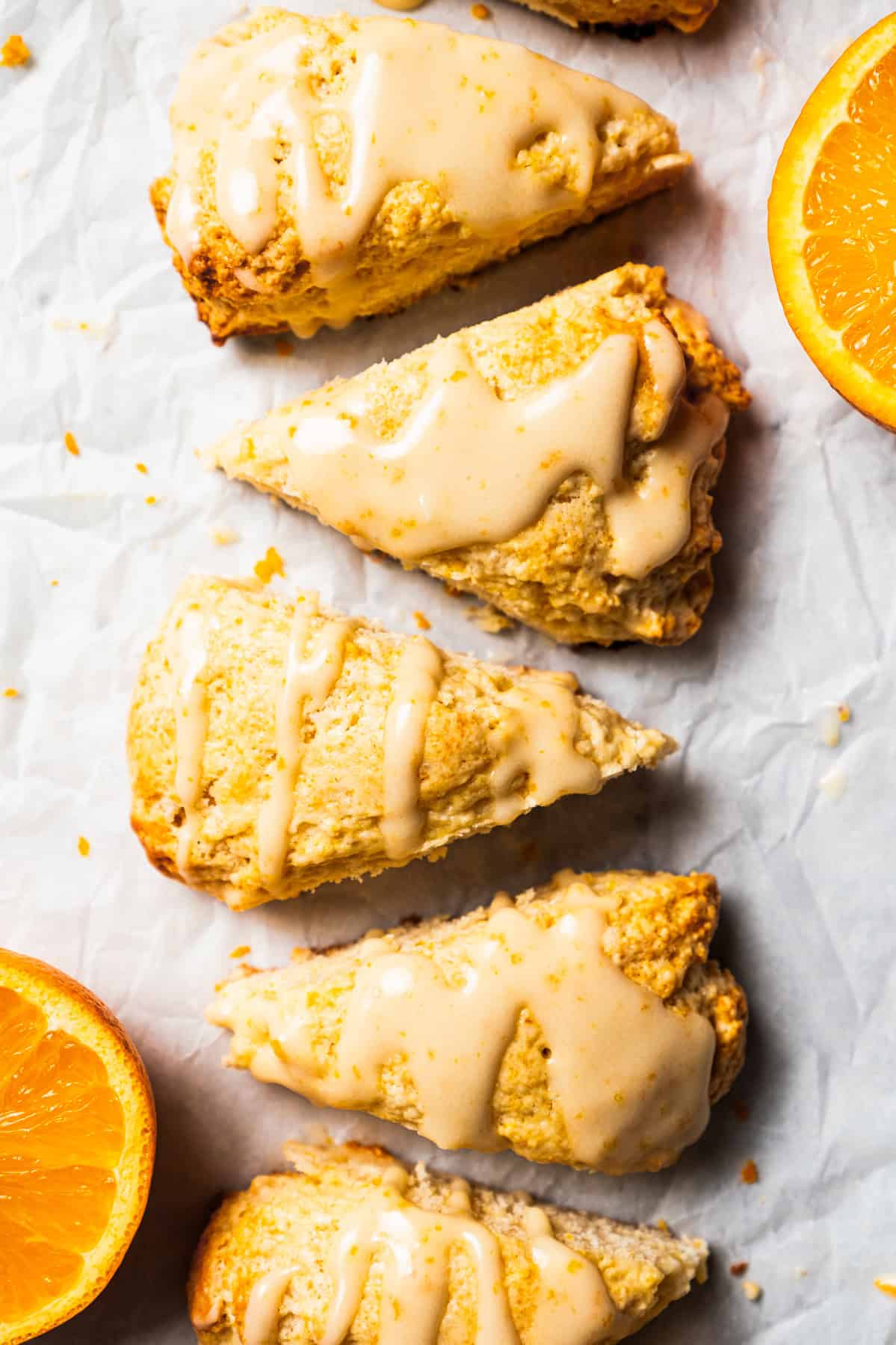 Vanilla orange scones on a parchment-lined surface.