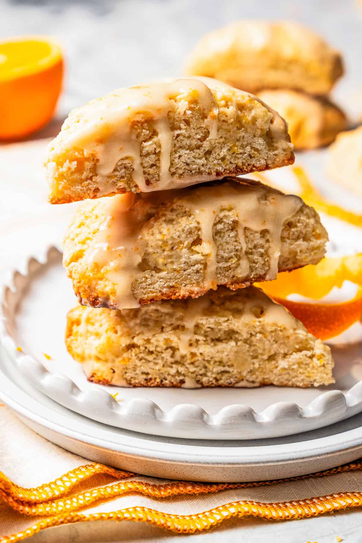 Three orange scones are stacked on a plate.