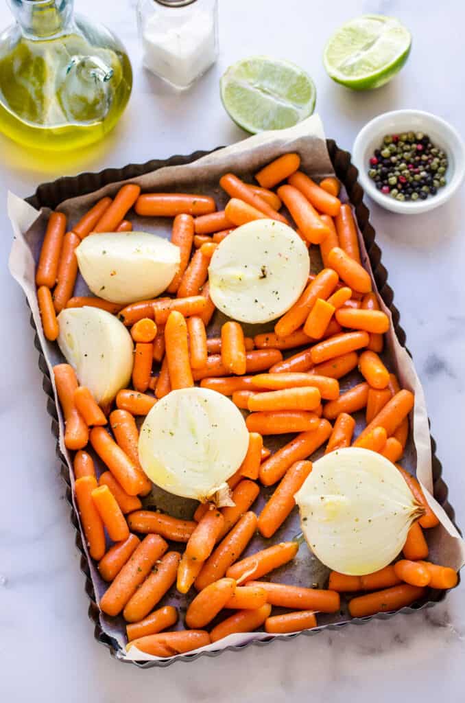 Carrots and onions on a baking sheet.