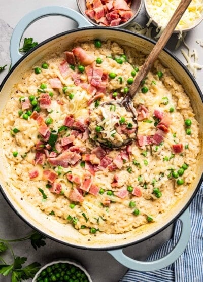 Stirring through risotto topped with bacon and peas.