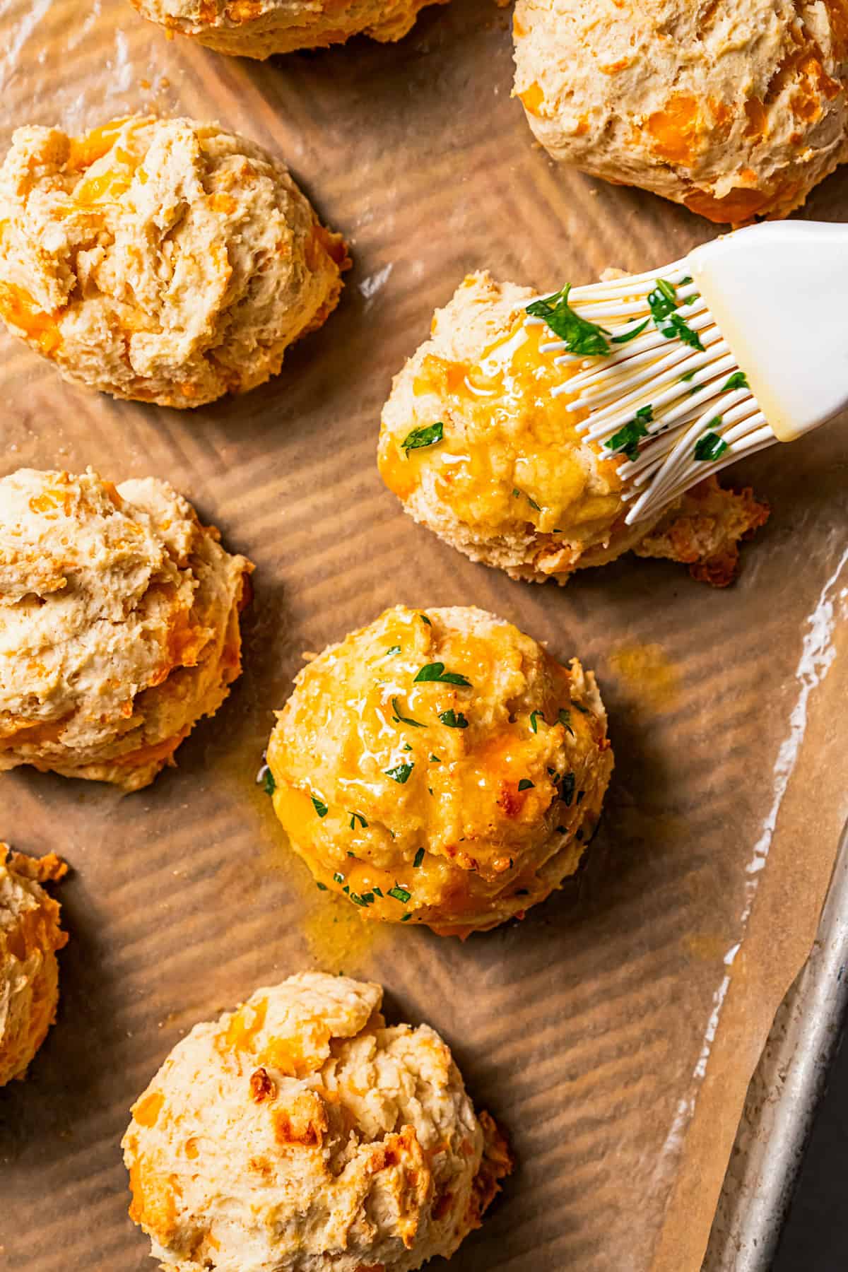 Brushing biscuits with garlic butter.