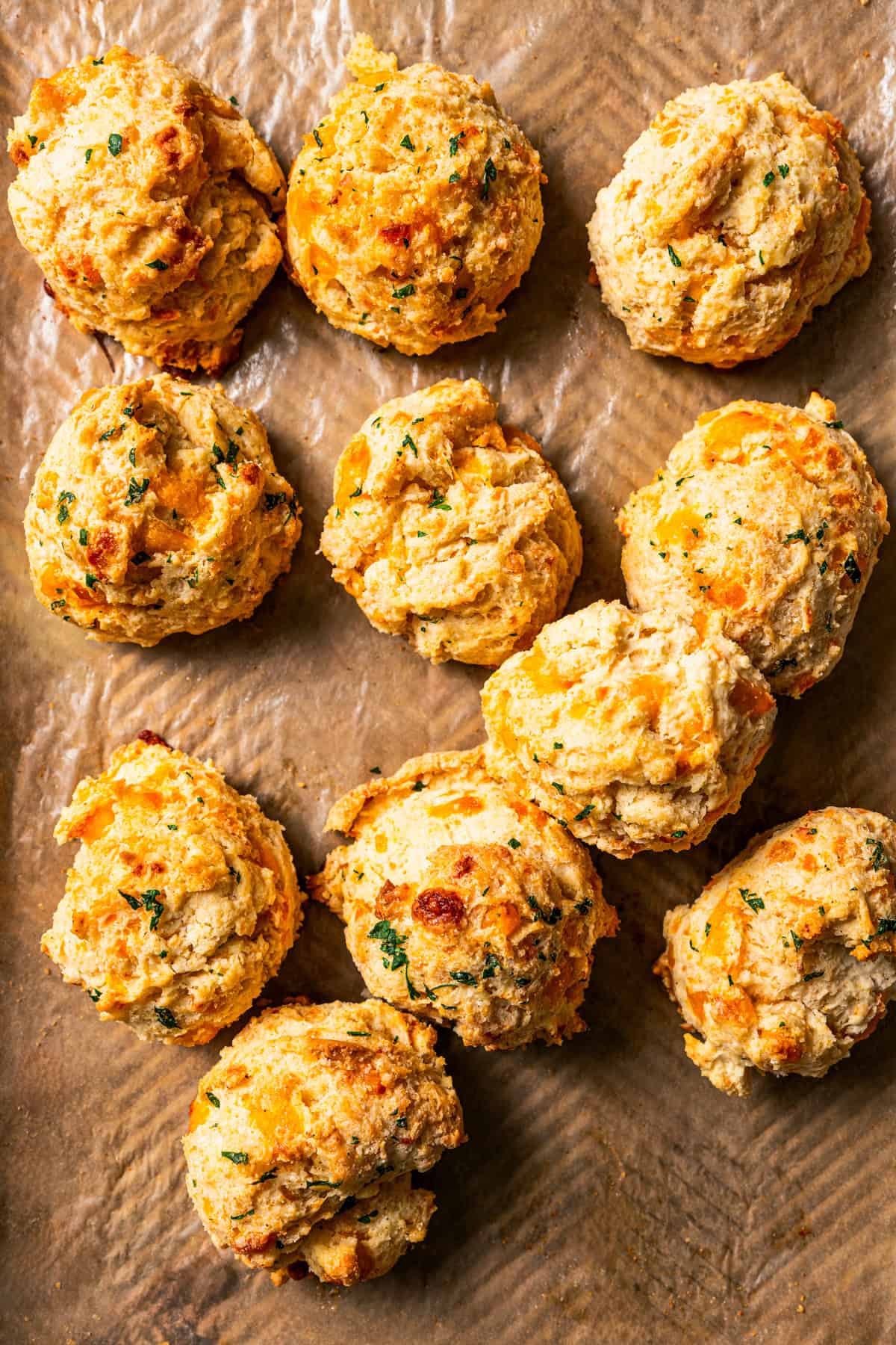 Assorted baked biscuits on a sheet of brown parchment paper.