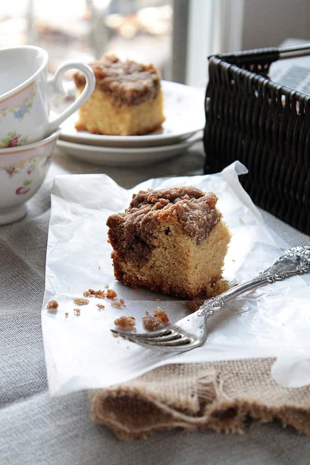 A slice of breakfast cake with a thick layer of cinnamon streusel topping on a napkin.