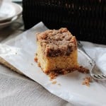 New York Crumb Cake on a napkin next to a fork surrounded by crumbled bits of streusel.