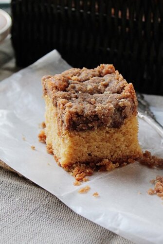 New York Crumb Cake on a napkin next to a fork surrounded by crumbled bits of streusel.