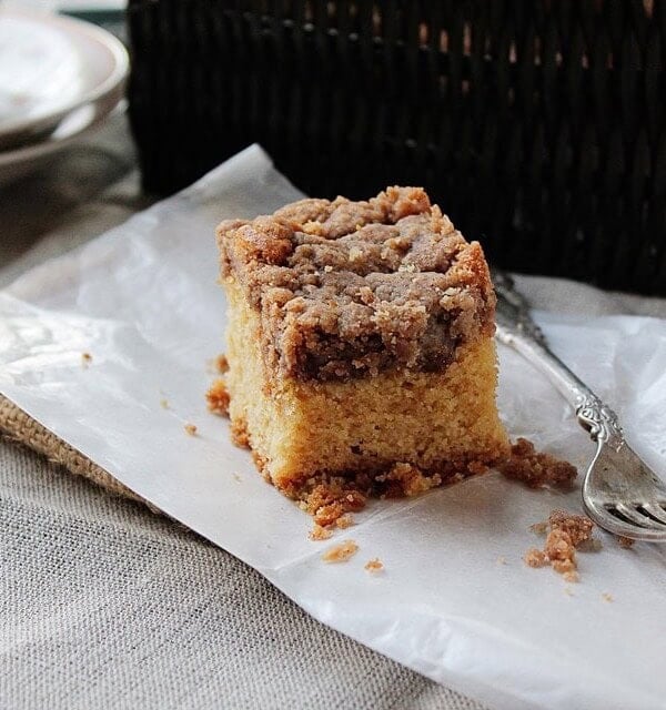 New York Crumb Cake on a napkin next to a fork surrounded by crumbled bits of streusel.