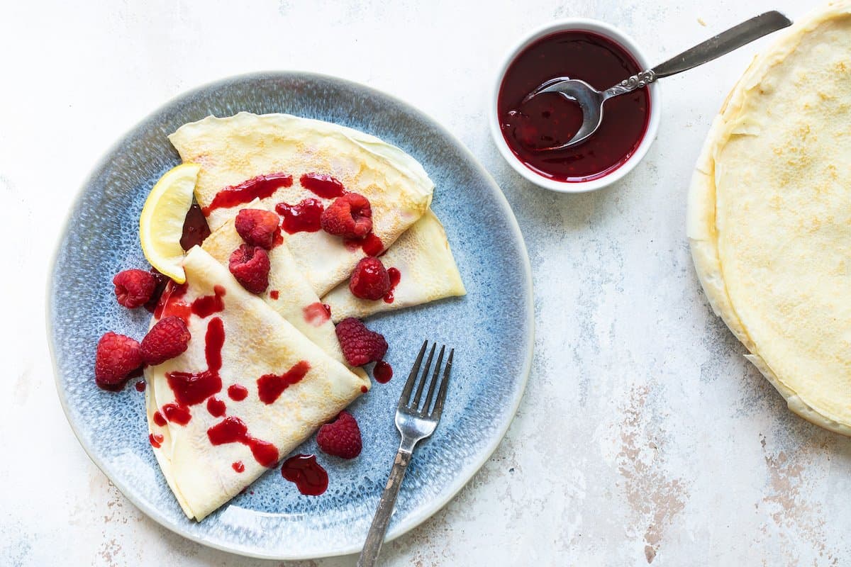 Lemon crepes covered in raspberry sauce.