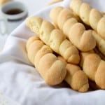 Braided Butter Cookies on a white cloth with a cup of tea behind it
