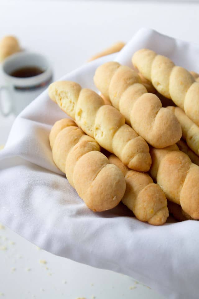 Braided Butter Cookies on a white cloth with a cup of tea behind it