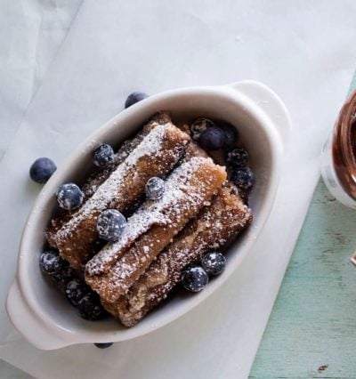 French Toast Rollups in a white dish next to a jar of nutella