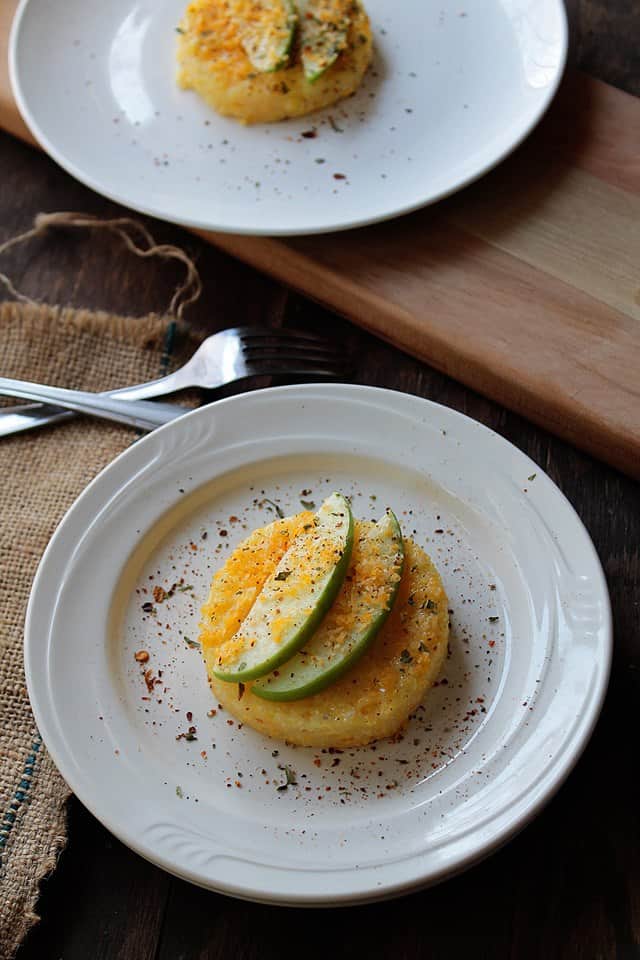 Polenta Cakes with Apples and Cheddar on a white plate.